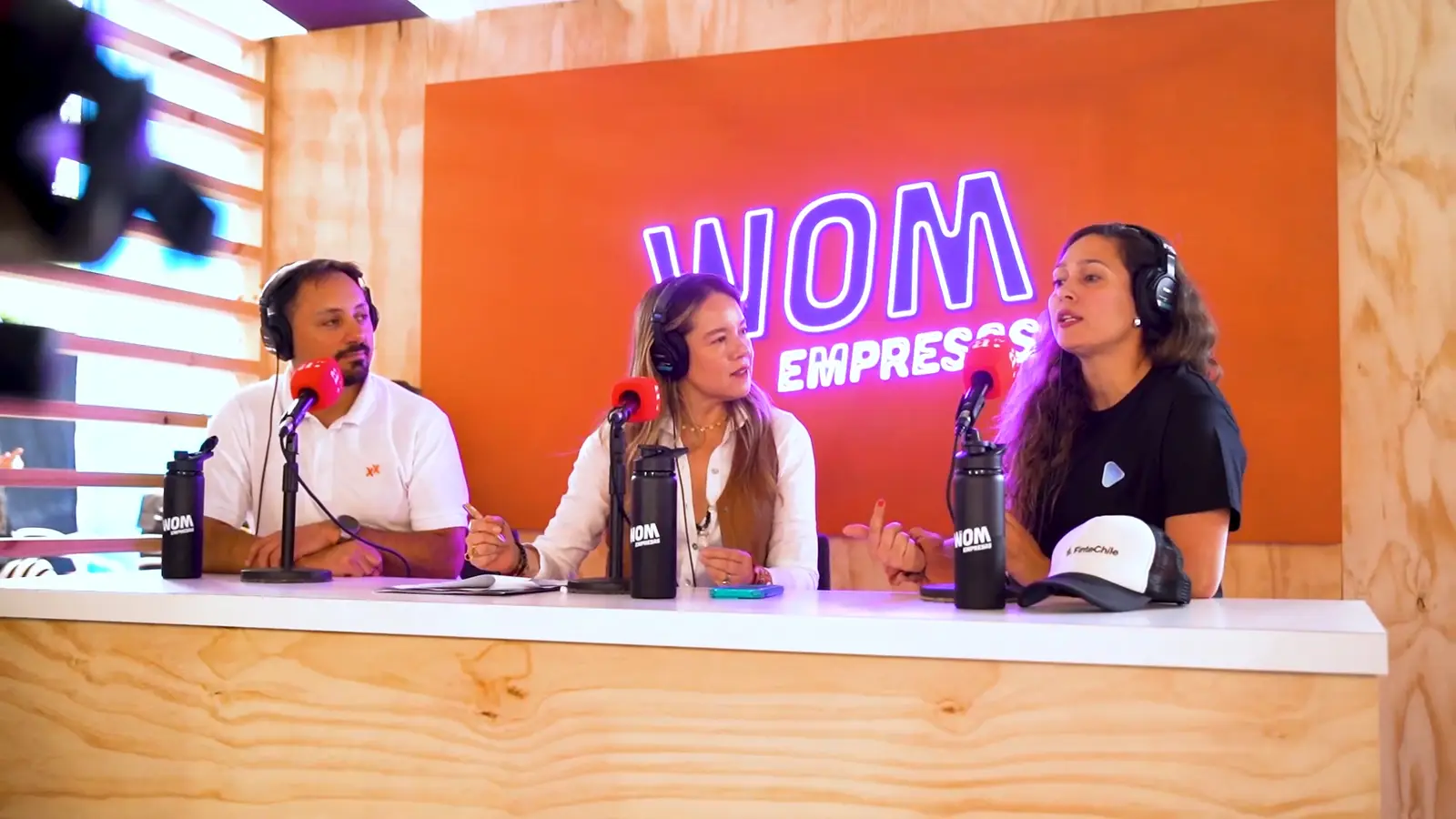 WOM Empresas — panel de tres invitados en el set del evento